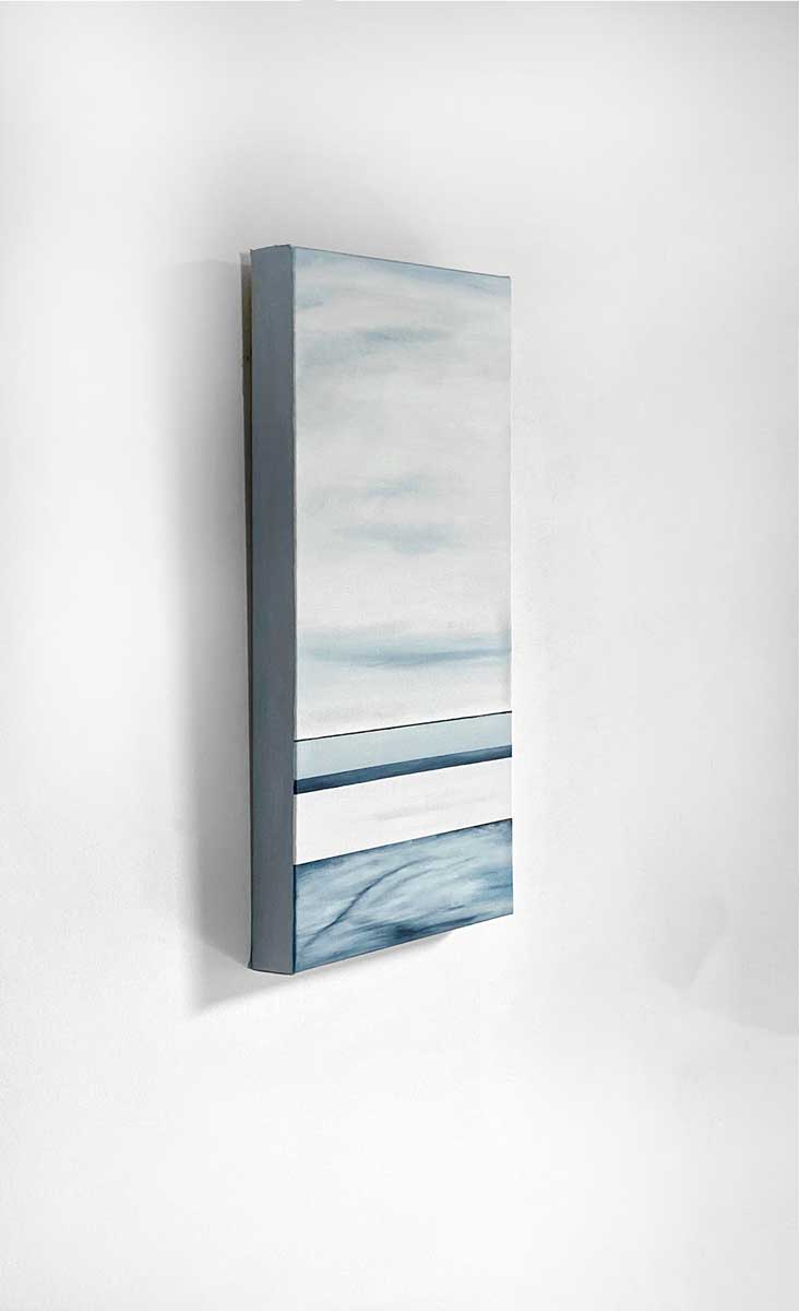 A left side-angle view of blue and white abstract painting on a white wall.