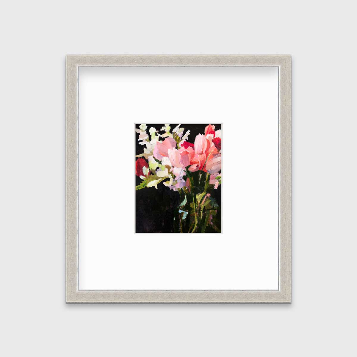 A pink, black and green abstract floral print in a silver frame with a mat hangs on a white wall.