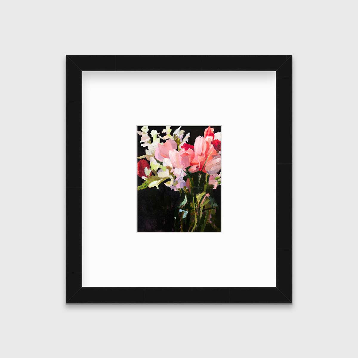 A pink, black and green abstract floral print in a black frame with a mat hangs on a white wall.