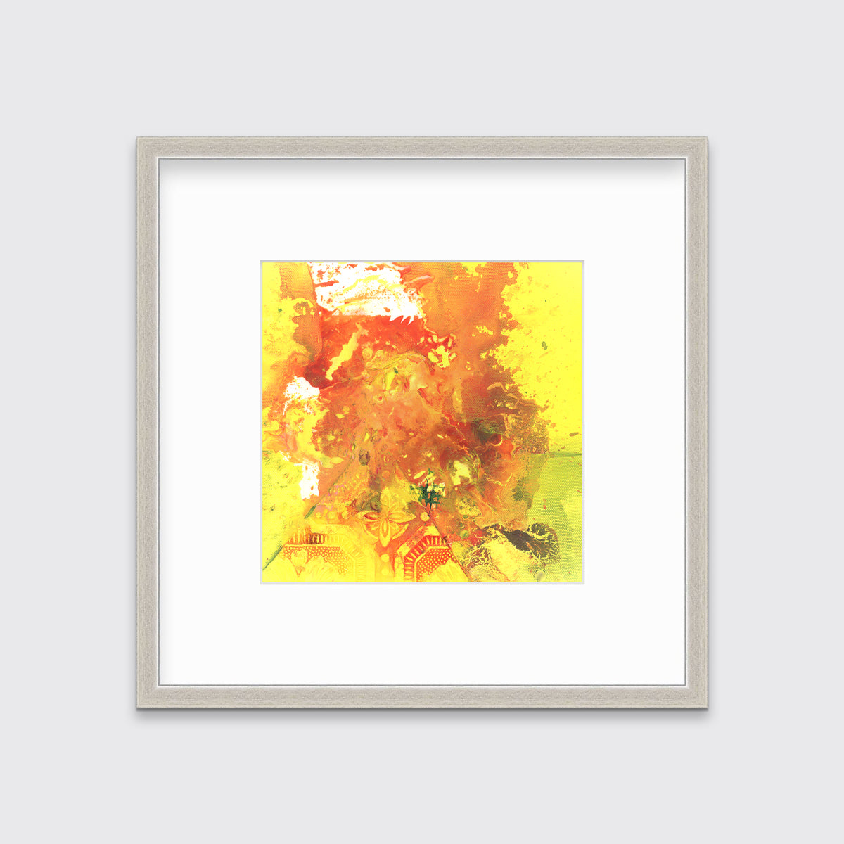 A yellow, orange and white abstract print in a silver frame with a mat hangs on a white wall.