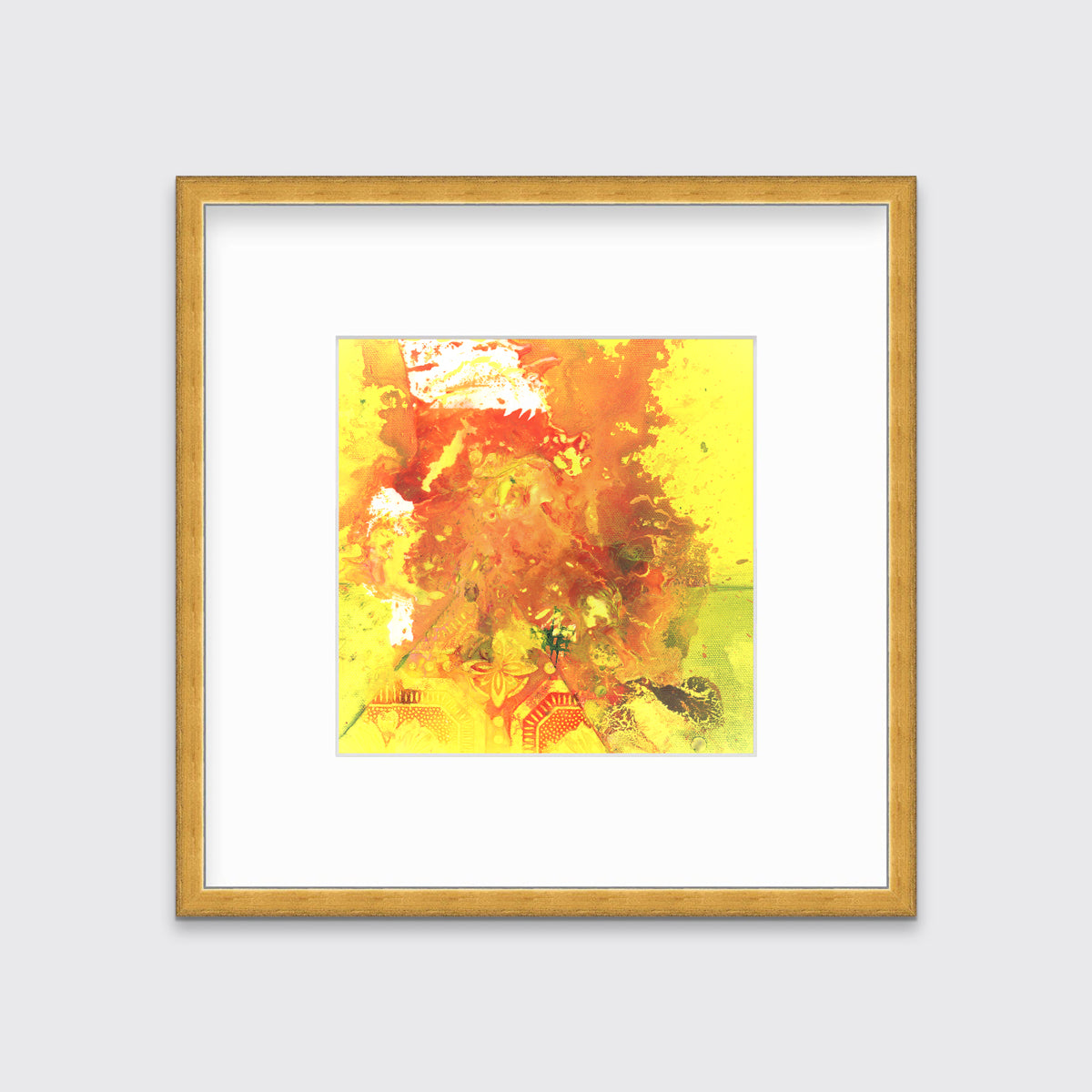 A yellow, orange and white abstract print in a gold frame with a mat hangs on a white wall.