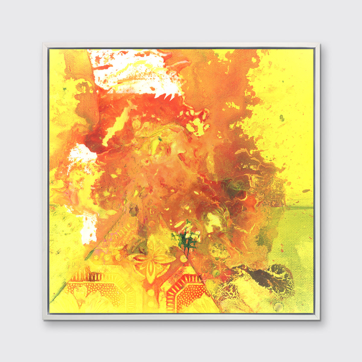 A yellow, orange and white abstract print in a white floater frame hangs on a white wall.