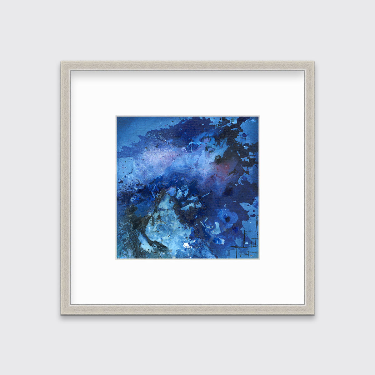 A blue and black abstract print in a silver frame with a mat hangs on a white wall.