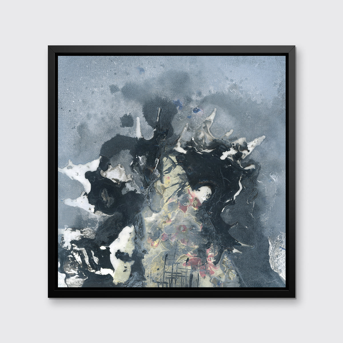 A grey, black, white and light yellow abstract print in a black floater frame hangs on a white wall.