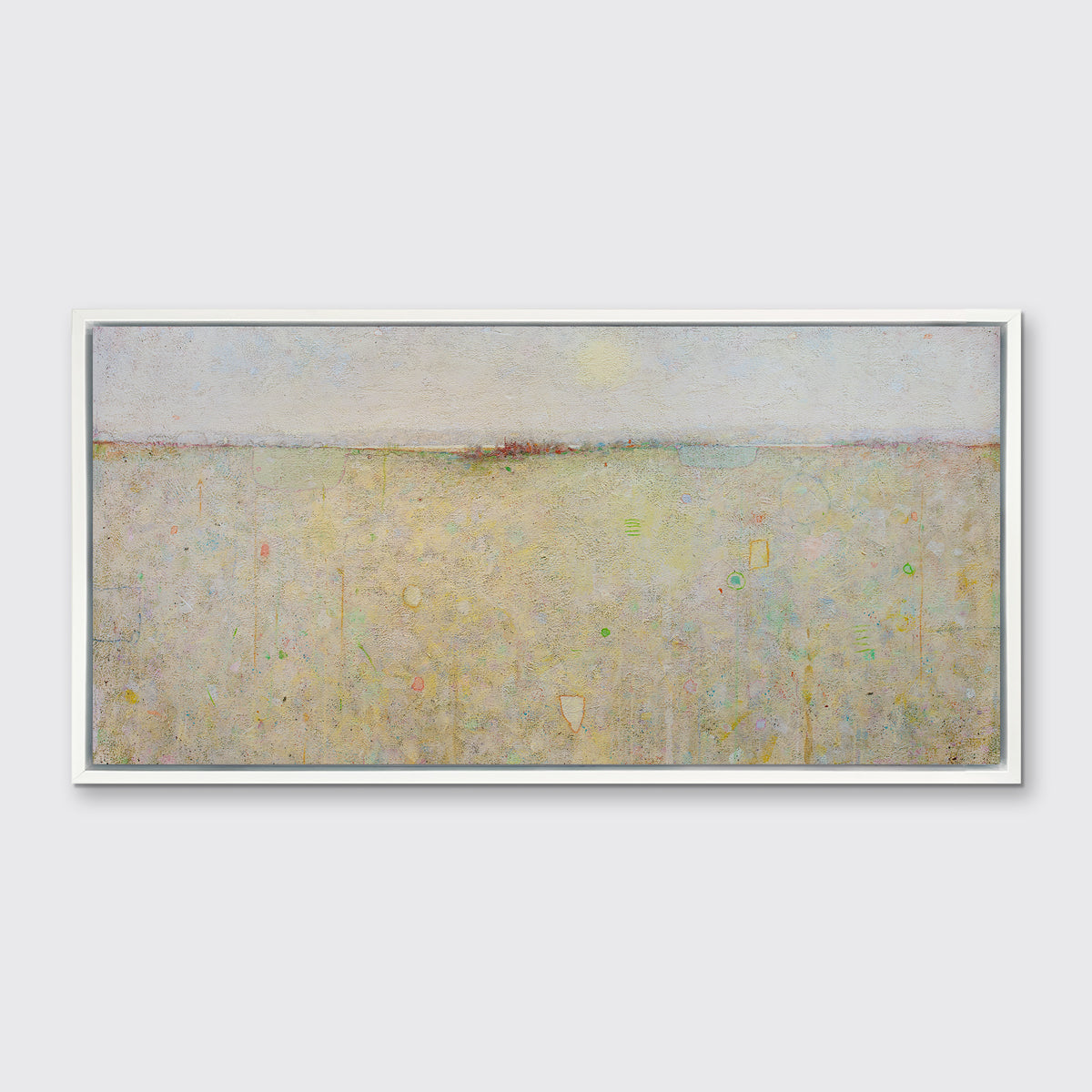 A yellow and white abstract landscape print in a white floater frame hangs on a white wall.