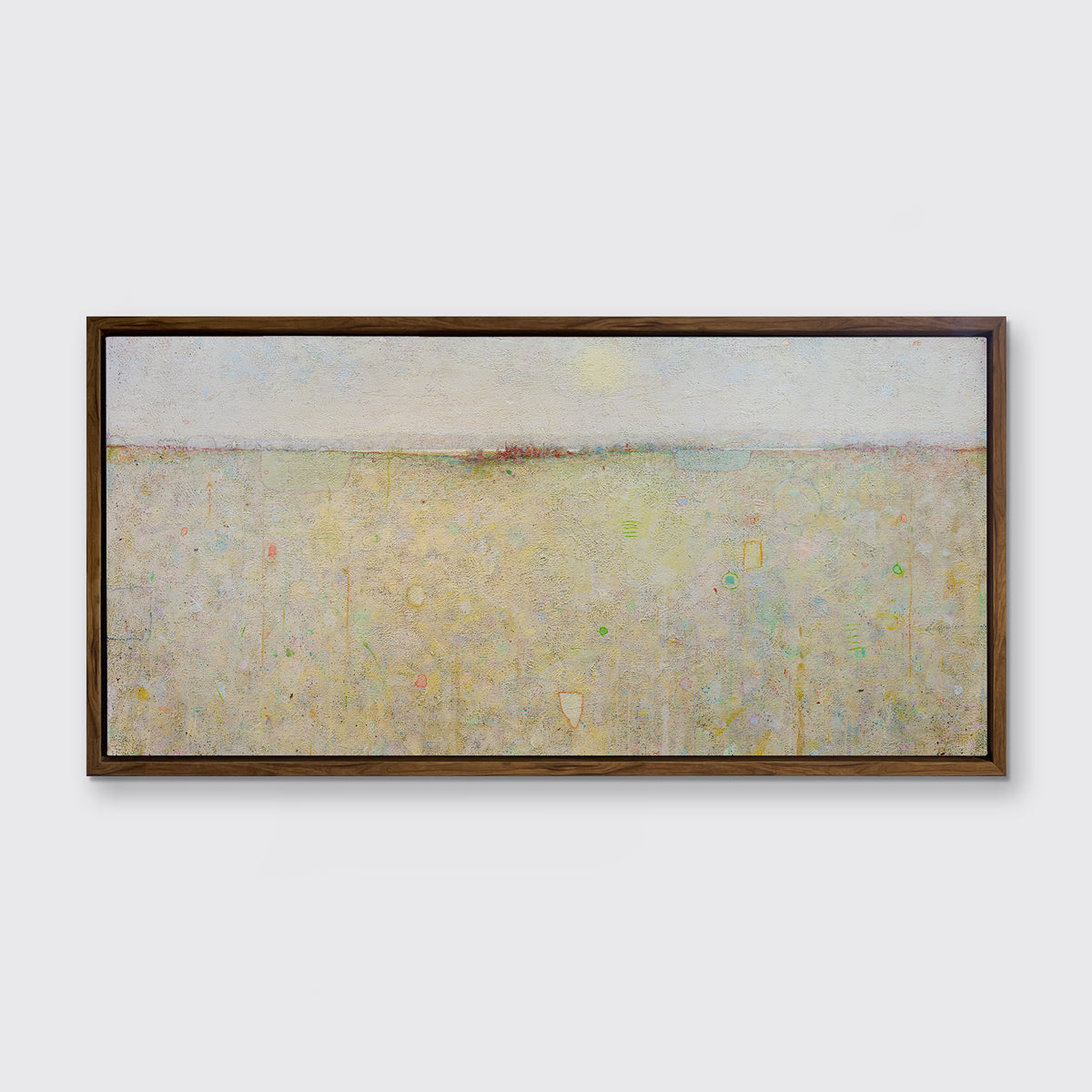 A yellow and white abstract landscape print in an oak wood floater frame hangs on a white wall.