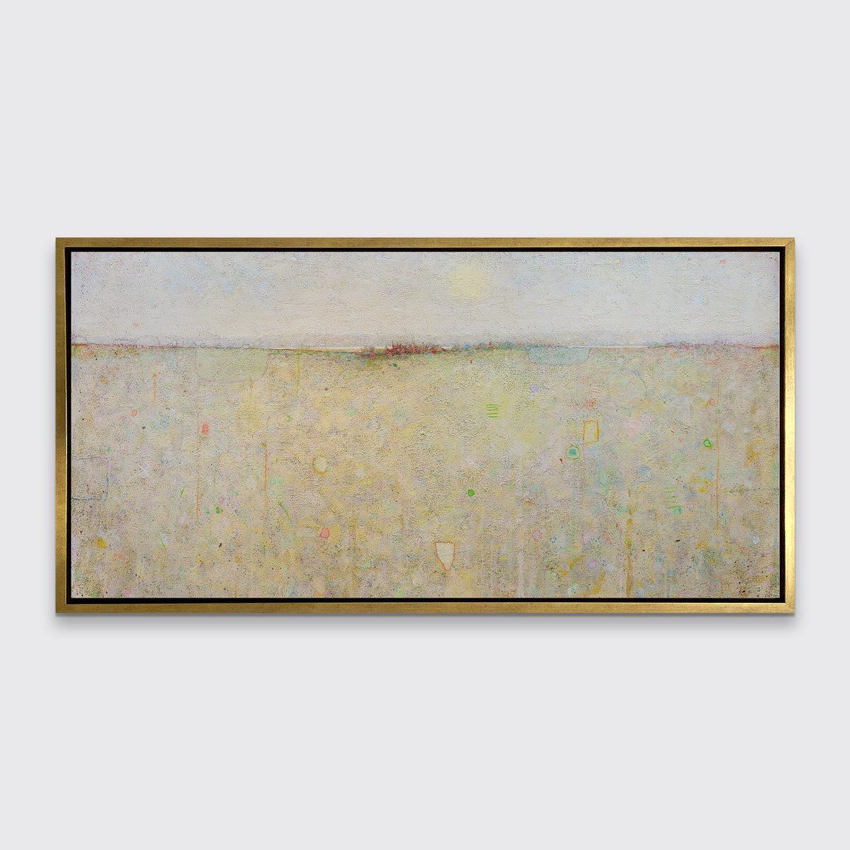 A yellow and white abstract landscape print in a gold floater frame hangs on a white wall.