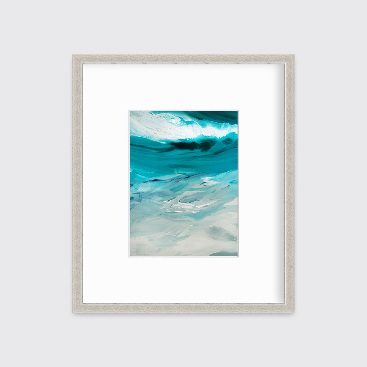 A teal, white and grey abstract print in a silver frame with a mat hangs on a white wall.