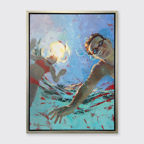 A figurative print of two kids underwater in a silver floater frame hangs on a white wall.