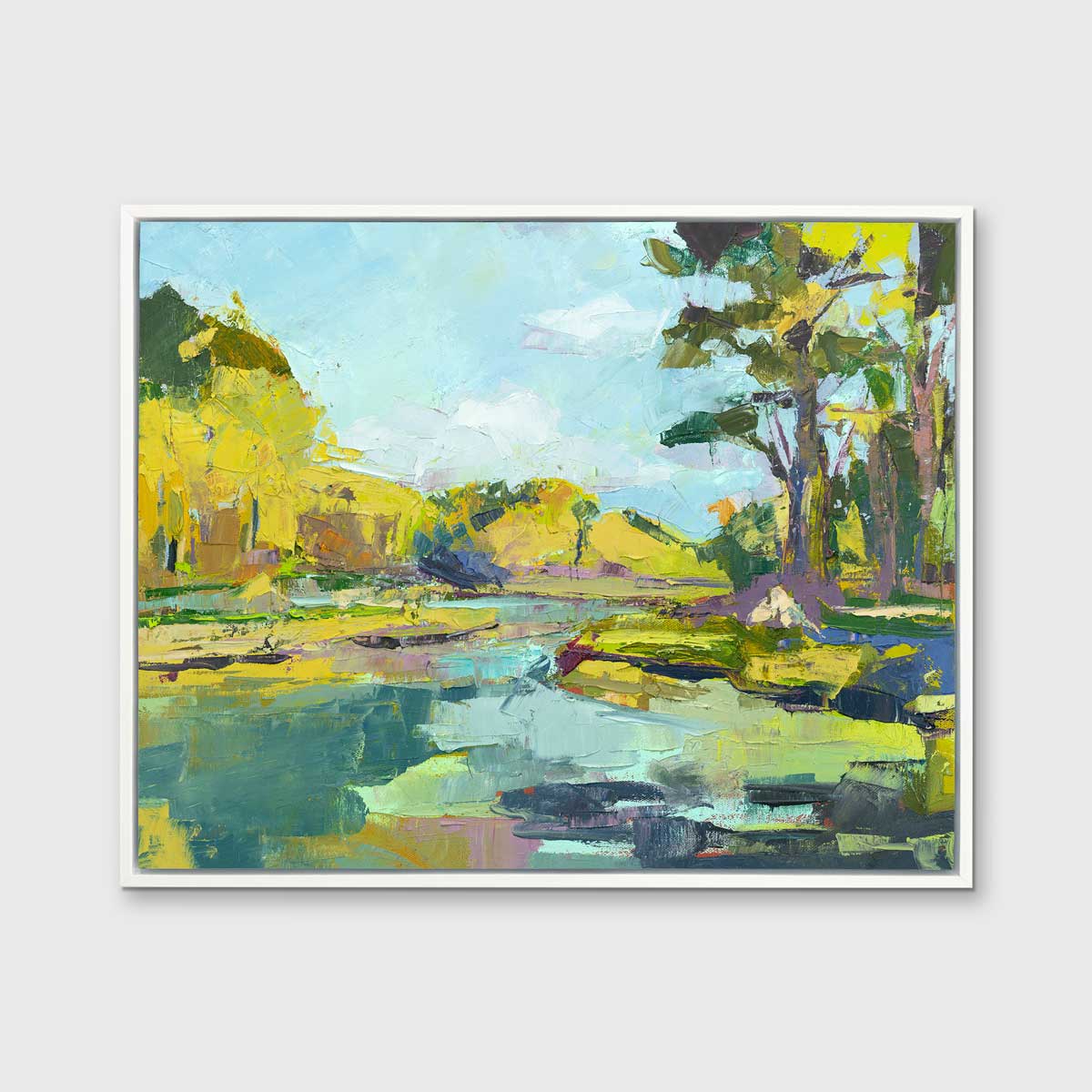 A chartreuse, light blue and green abstract landscape print in a white floater frame hangs on a white wall.