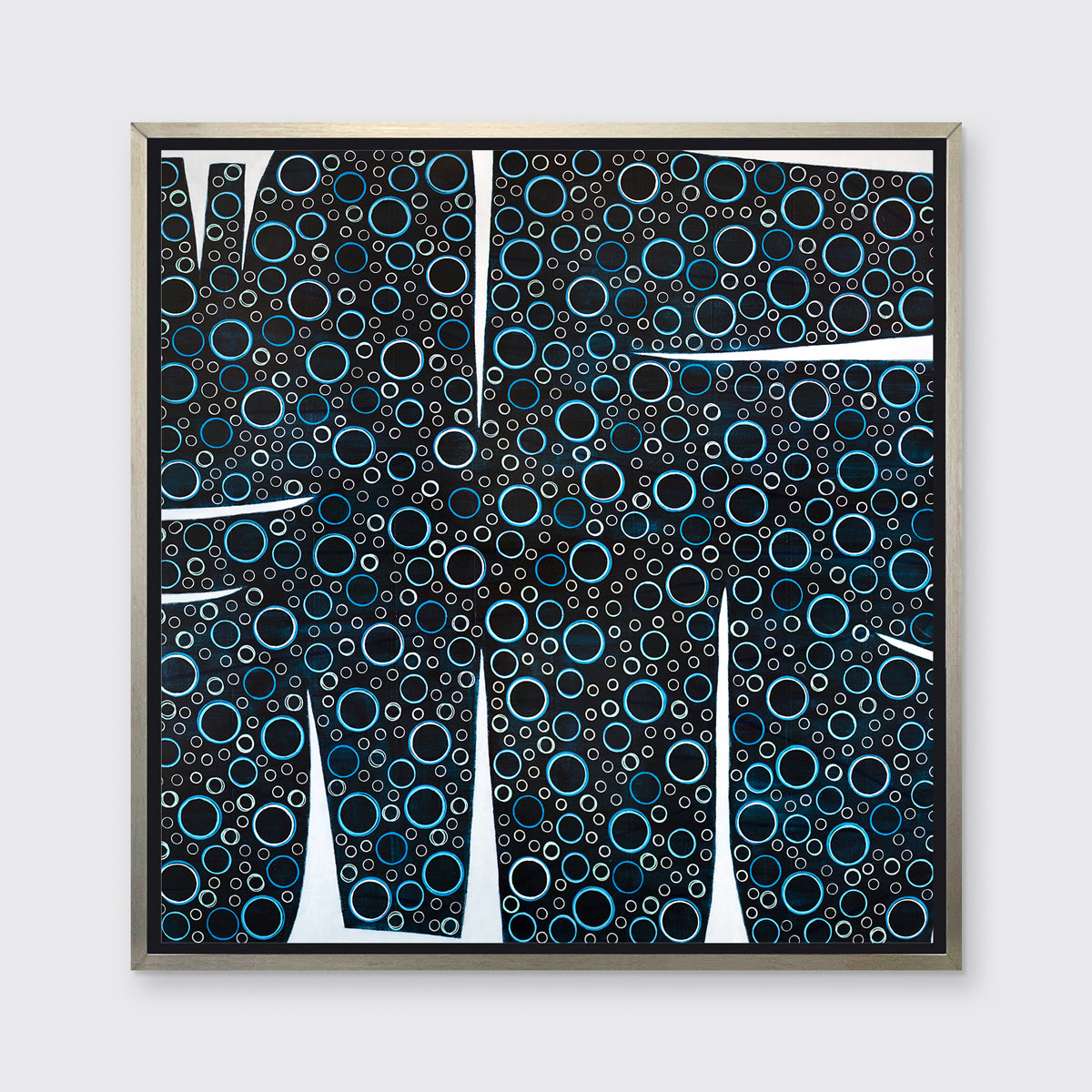 A black, blue and white abstract print in a silver floater frame hangs on a white wall.