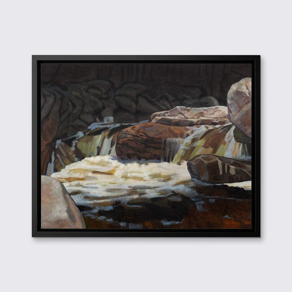 A brown, black and white abstract river landscape print in a black floater frame hangs on a white wall.