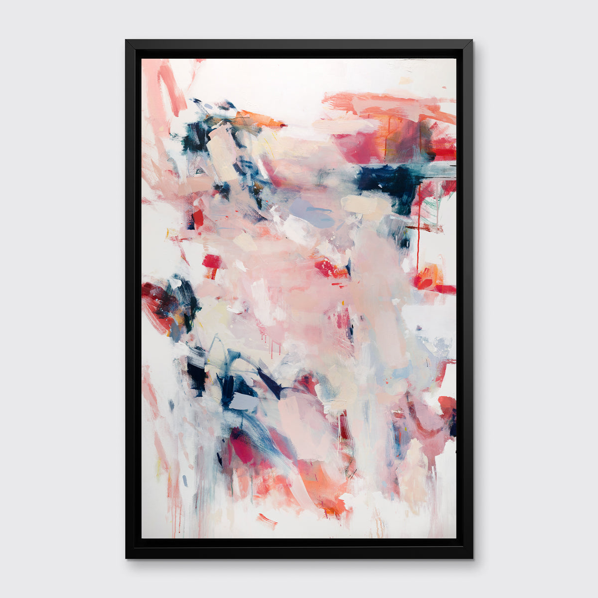 A pink, white and blue abstract print in a black floater frame hangs on a white wall.