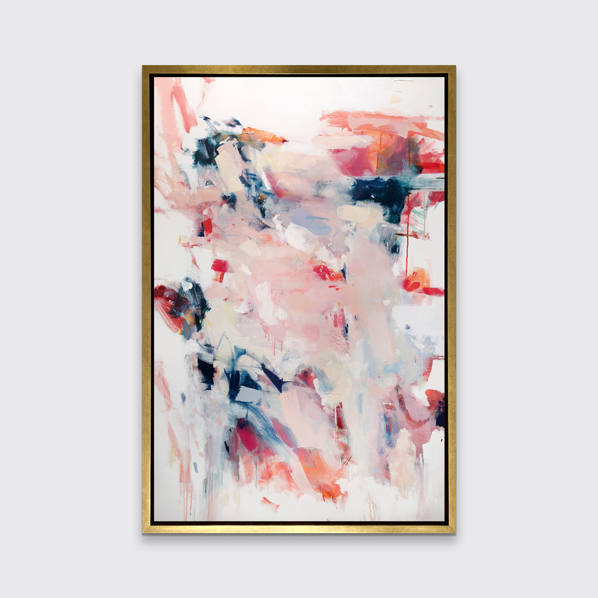 A pink, white and blue abstract print in a gold floater frame hangs on a white wall.