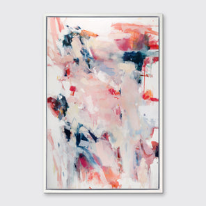 A pink, white and blue abstract print in a white floater frame hangs on a white wall.