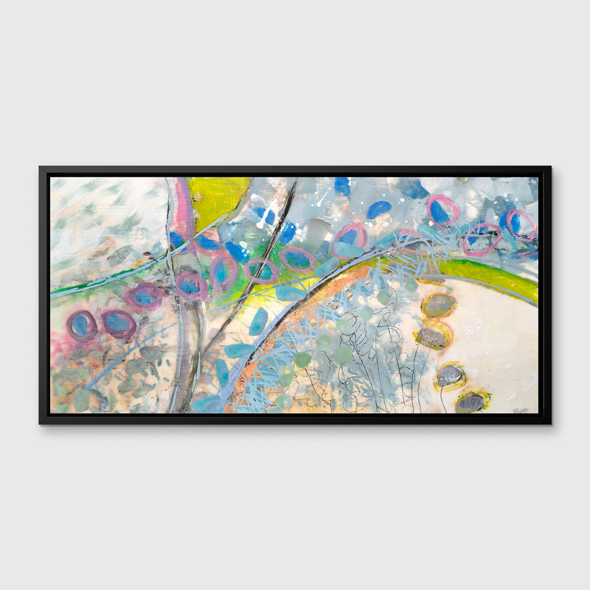 A multicolored abstract print in a black floater frame hangs on a white wall.