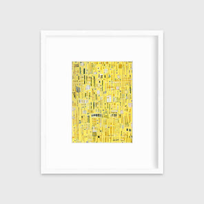 A yellow, white and black abstract print in a white frame with a mat hangs on a white wall.