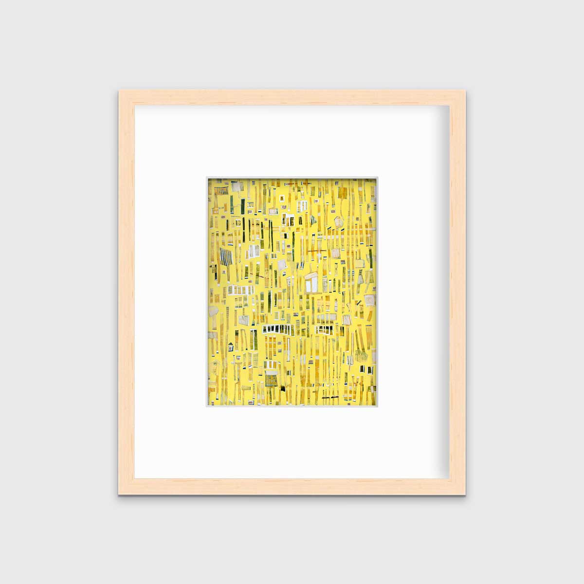 A yellow, white and black abstract print in a natural wood frame with a mat hangs on a white wall.