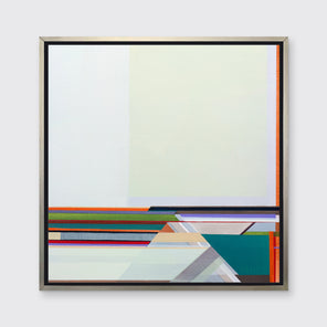 A multicolored geometric abstract print in a silver floater frame hangs on a white wall.