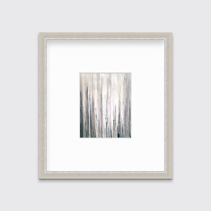 A white, cream and charcoal print in a silver frame with a mat hangs on a white wall.