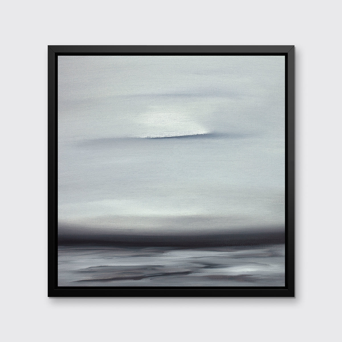 A tonal grey and black print in a black floater frame hangs on a white wall.