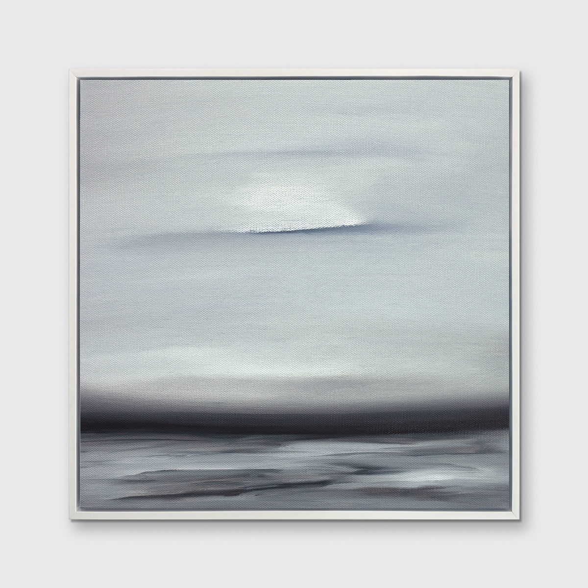 A tonal grey and black print in a white floater frame hangs on a white wall.