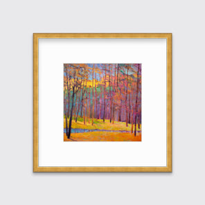 A multicolored abstract tree landscape print in a gold frame with a mat hangs on a white wall.