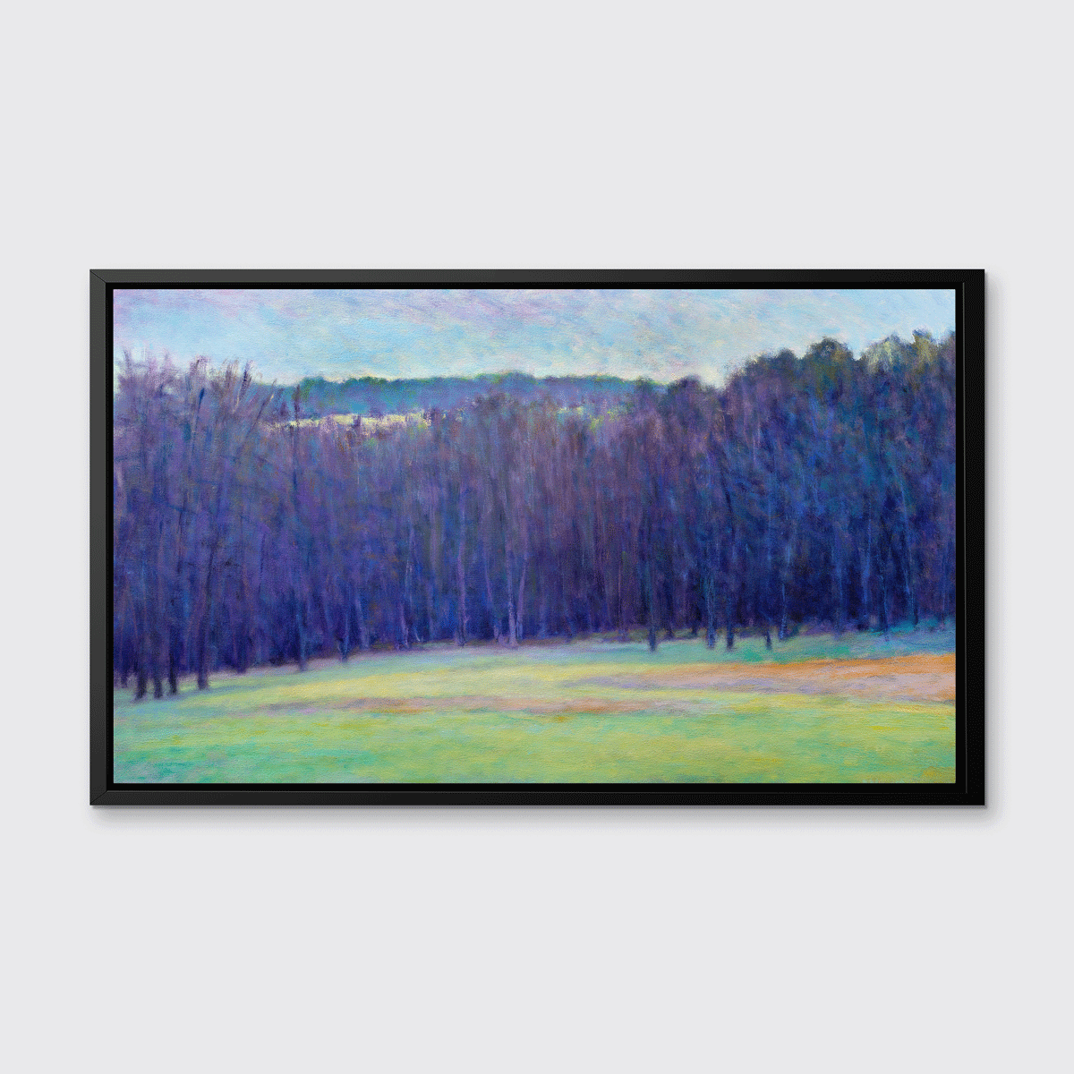 A blue, purple, light green and light orange impressionistic landscape print in a black floater frame hangs on a white wall.