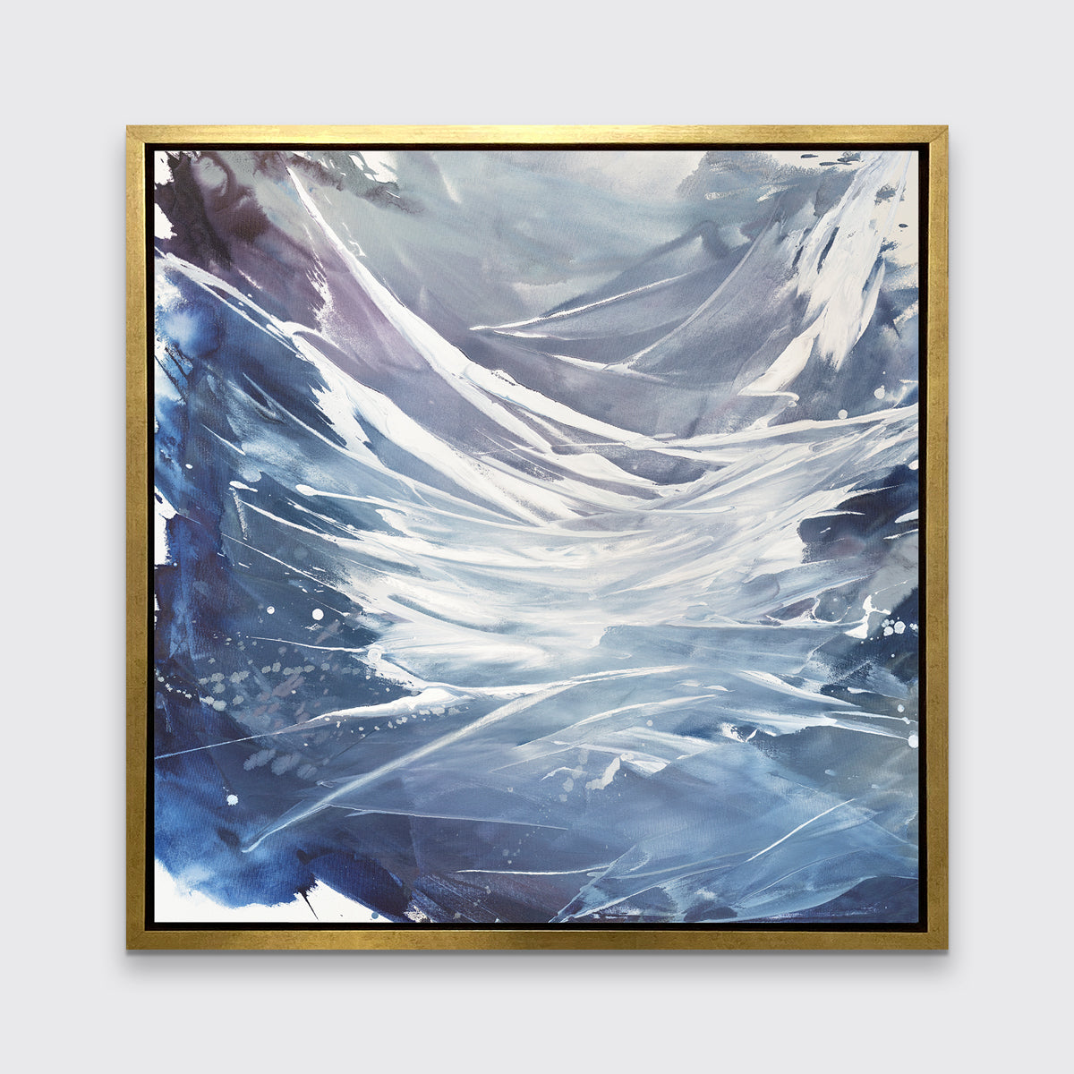 A light purple, grey, white and blue abstract print in a gold floater frame hangs on a white wall.