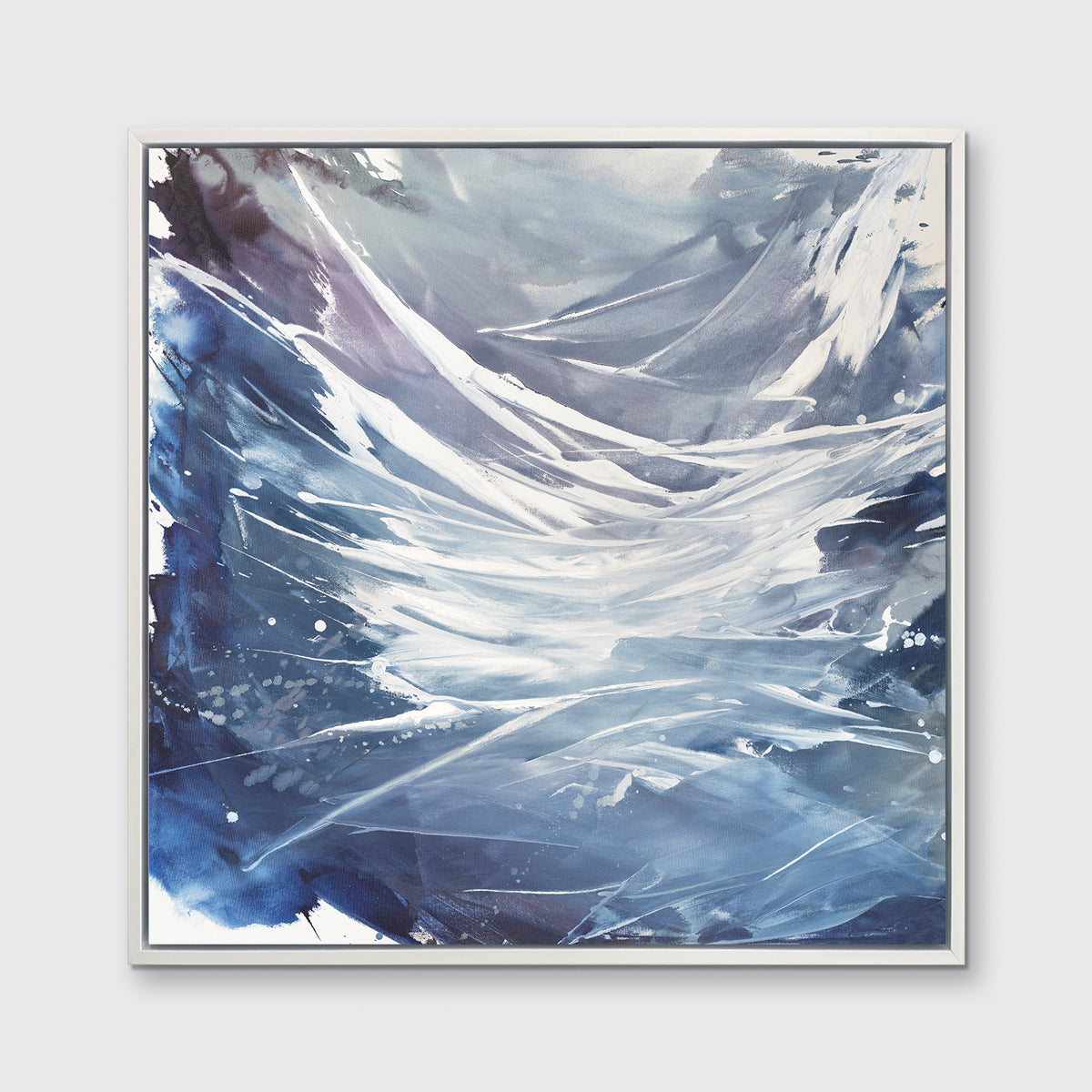 A light purple, grey, white and blue abstract print in a white floater frame hangs on a white wall.