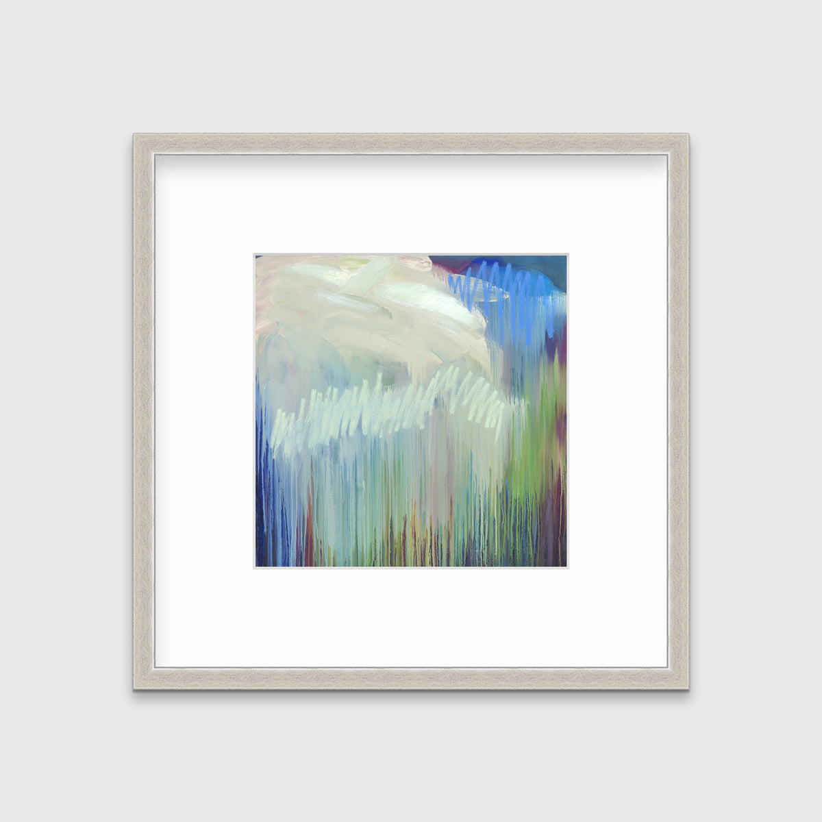 A multicolored abstract print in a silver frame with a mat hangs on a white wall.