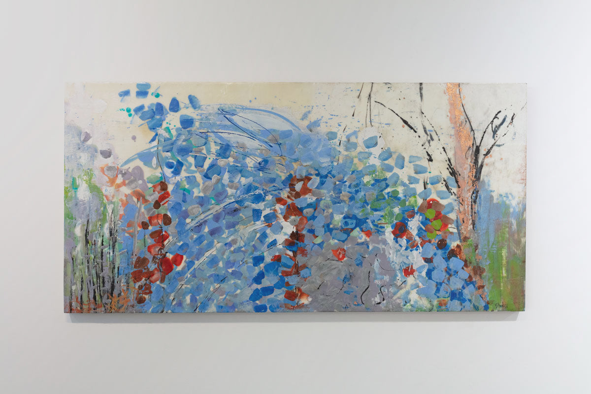 An encaustic painting with expressionistic floral motifs in red and blue is hung on a gallery wall. Wired and ready to hang.