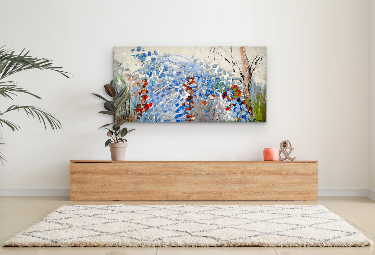 An encaustic painting with expressionistic floral motifs in red and blue is hung above a cedar chest. Wired and ready to hang.