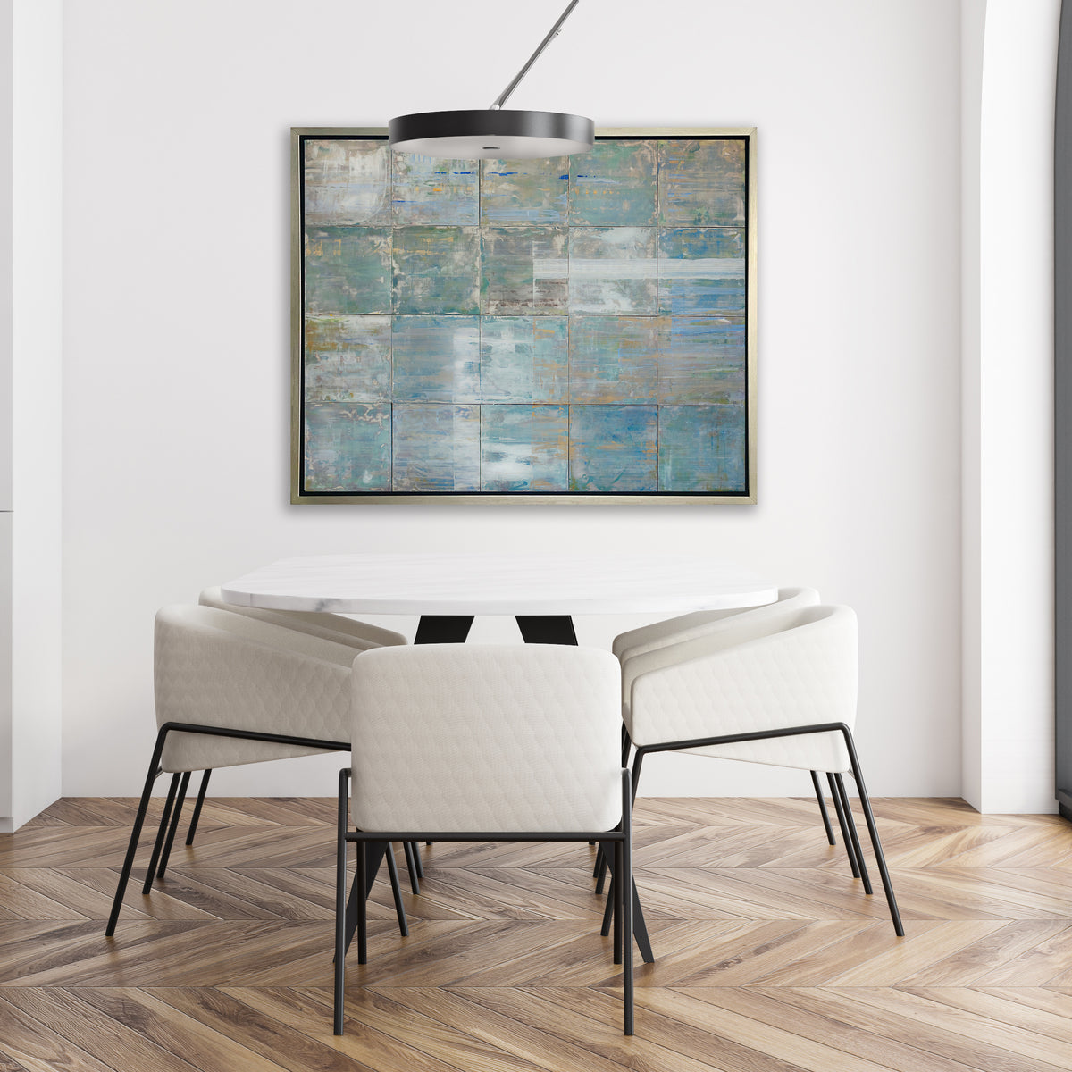 A blue and green abstract geometric print in a silver floater frame hangs on a white wall above a white marble table with five low white chairs.