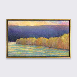 A purple, yellow, orange and blue abstract landscape print in a gold floater frame hangs on a white wall.
