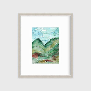 A blue, green and black abstract landscape print in a silver frame with a mat hangs on a white wall.