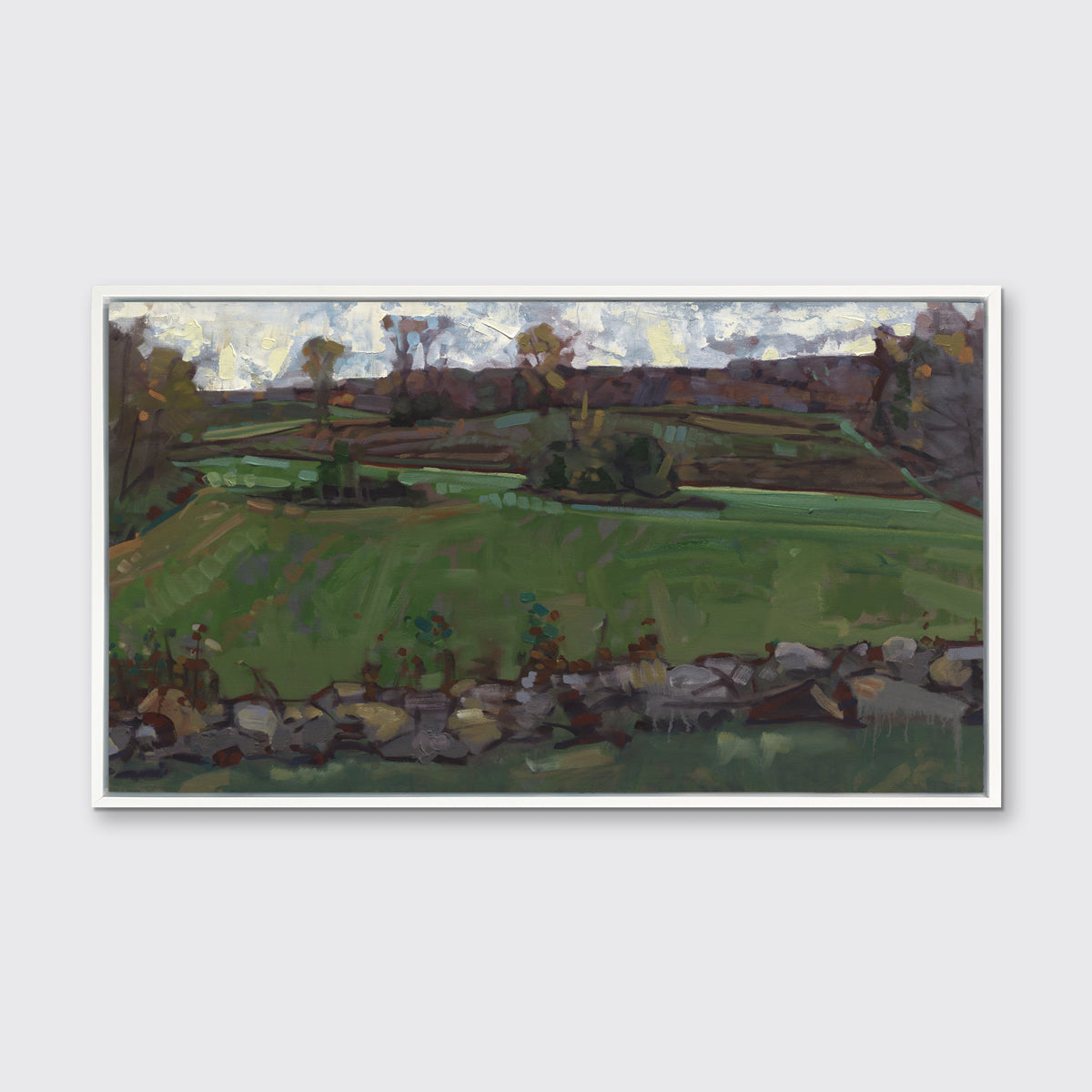 A green, brown and white abstract landscape print in a white floater frame hangs on white wall.