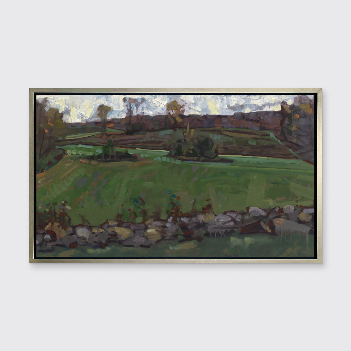 A green, brown and white abstract landscape print in a silver floater frame hangs on white wall.