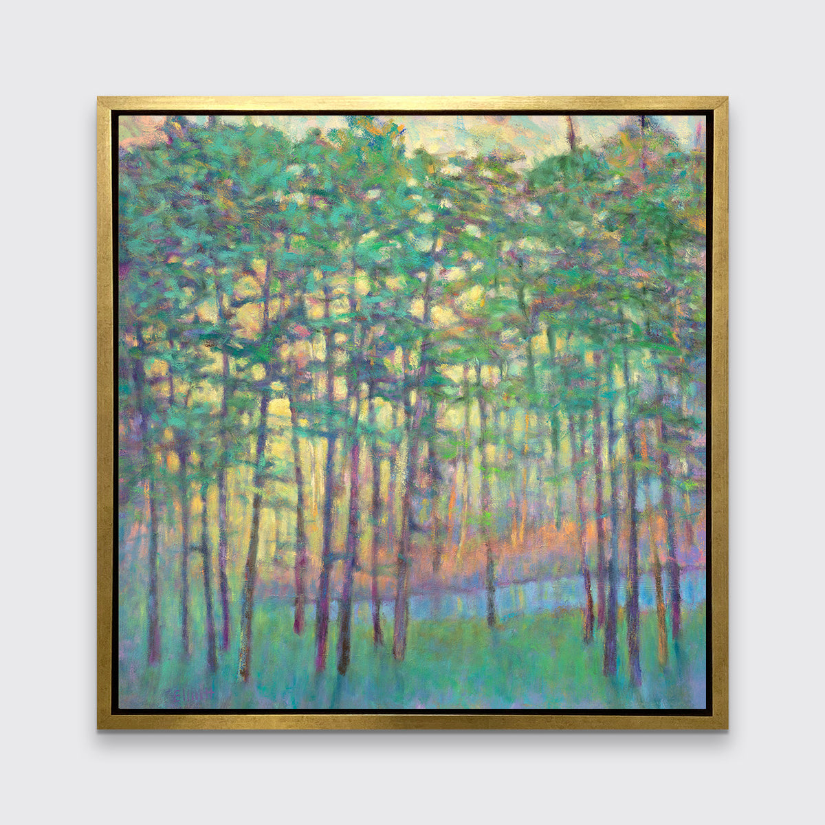 A green, yellow, orange and blue abstract tree landscape print in a gold floater frame hangs on a white wall.