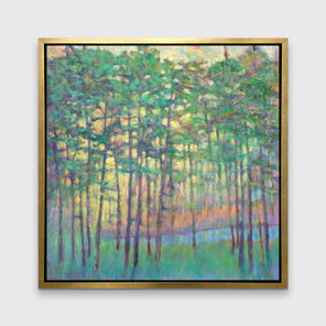 A green, yellow, orange and blue abstract tree landscape print in a gold floater frame hangs on a white wall.