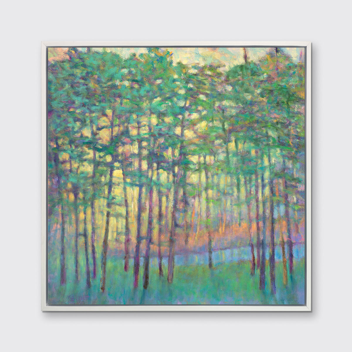 A green, yellow, orange and blue abstract tree landscape print in a white floater frame hangs on a white wall.