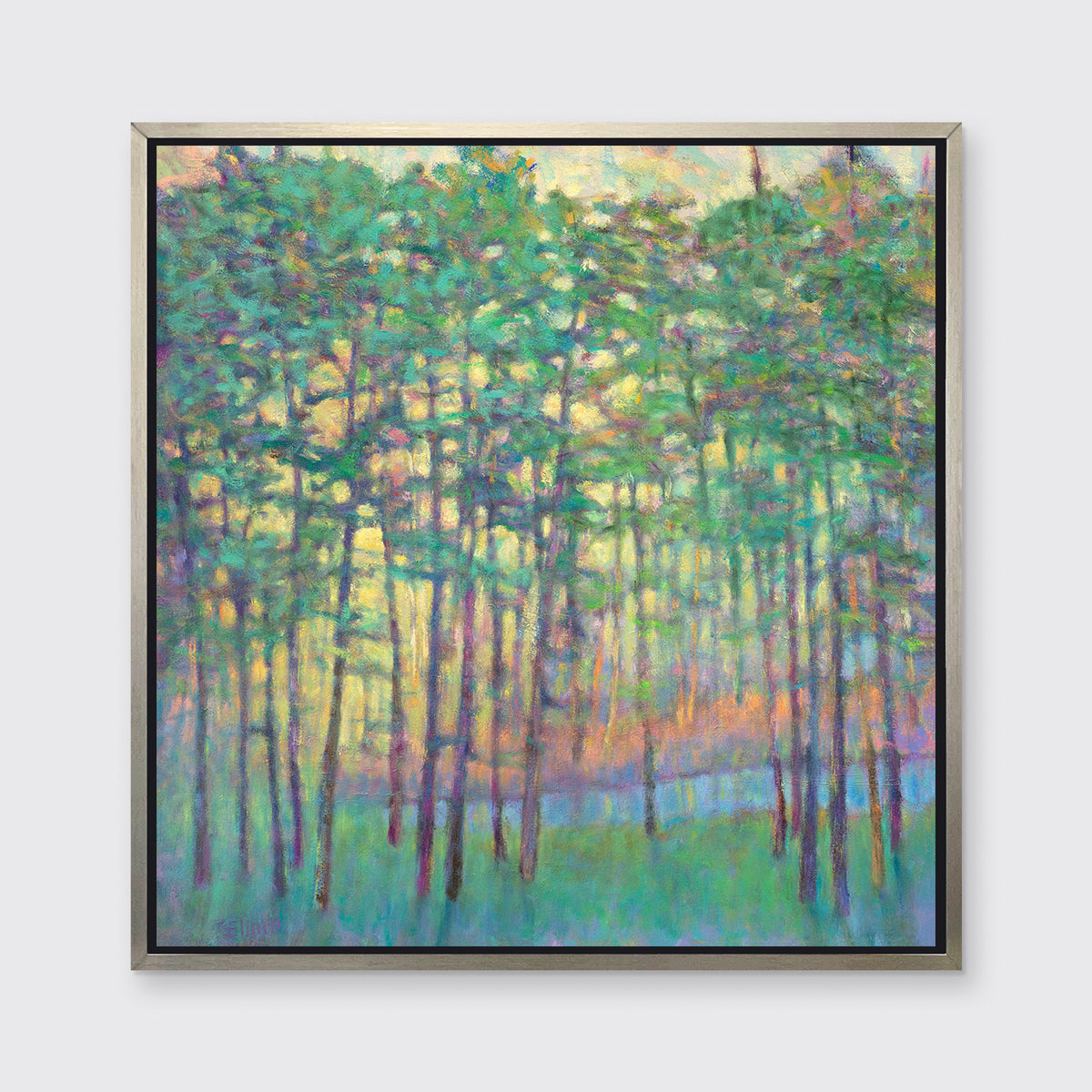 A green, yellow, orange and blue abstract tree landscape print in a silver floater frame hangs on a white wall.