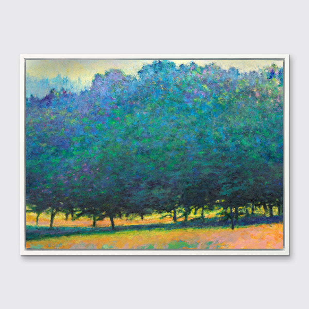 A green, orange and teal abstract tree landscape print in a white floater frame hangs on a white wall.