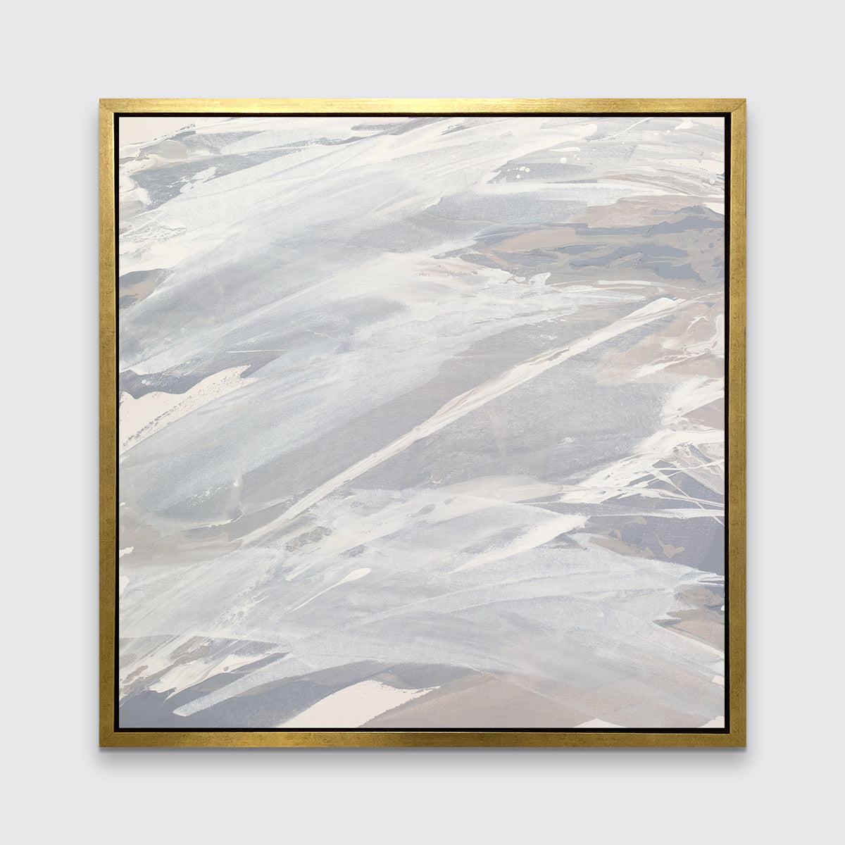 A grey, beige and white abstract print in a gold floater frame hangs on a white wall.