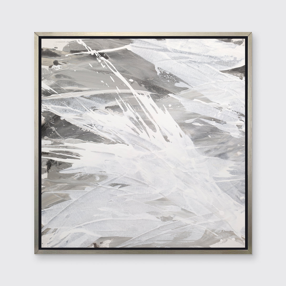 A grey, beige and white abstract print in a silver floater frame hangs on a white wall.
