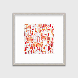 A red, orange and white abstract print in a silver frame with a mat hangs on a white wall.