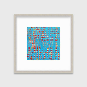 A blue, red, yellow and white abstract print in a silver frame with a mat hangs on a white wall.