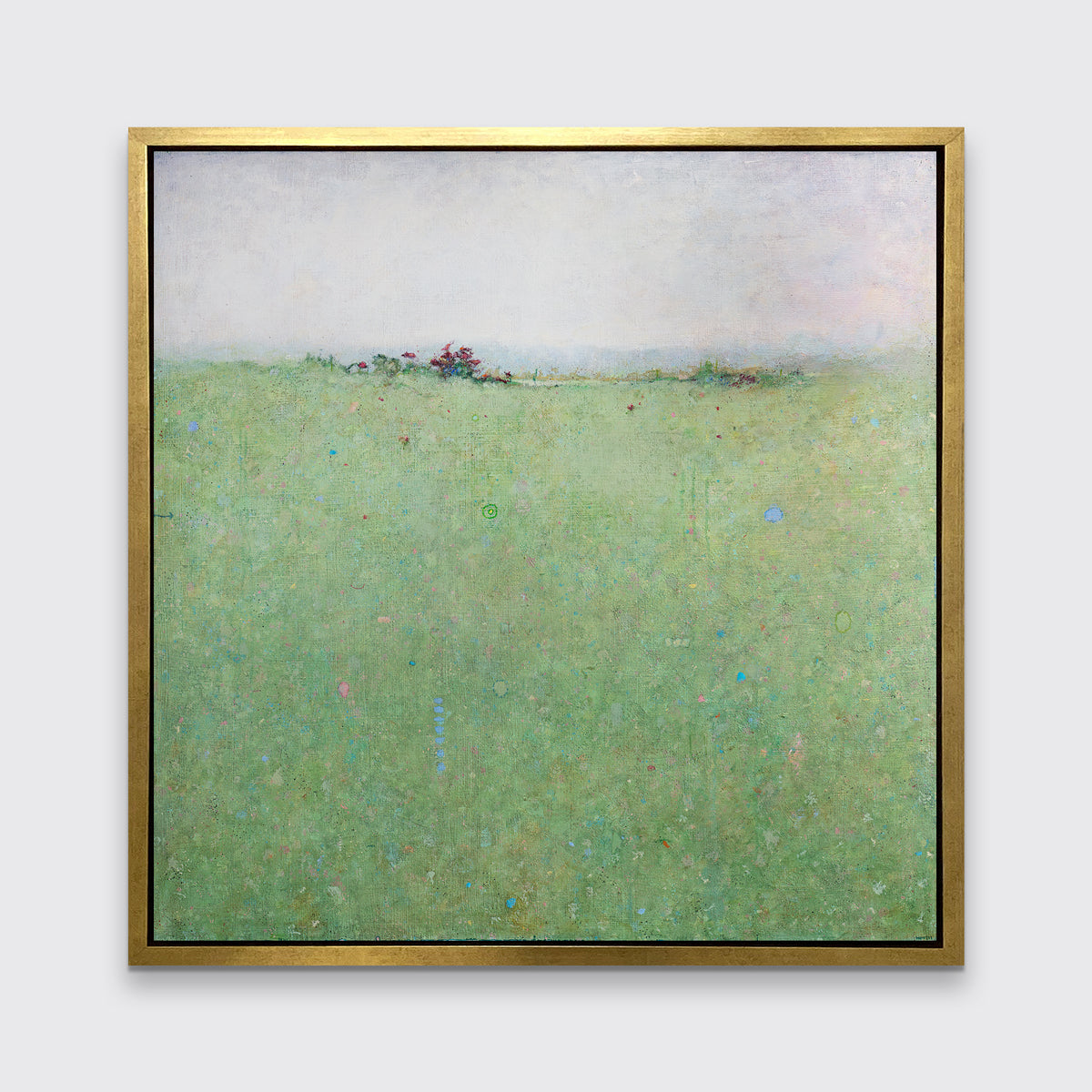A green abstract landscape print in a gold floater frame hangs on a white wall.