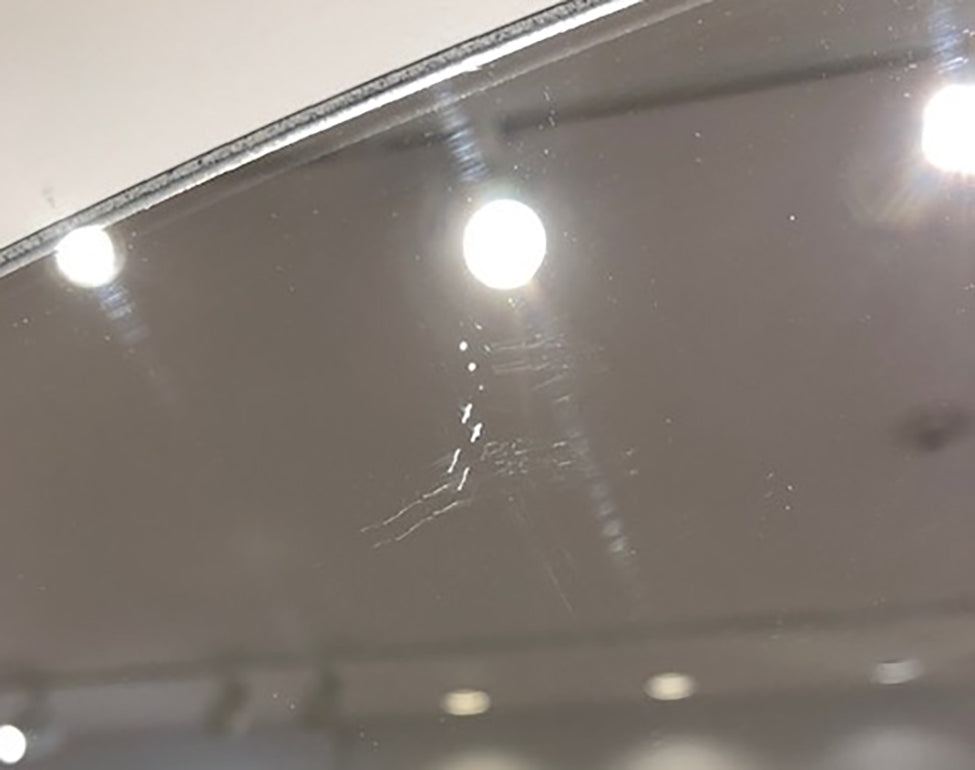 Detailed, close up of scratch mark on mirror.