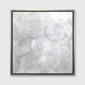 A grey and white abstract geometric print in a silver floater frame hangs on a white wall.